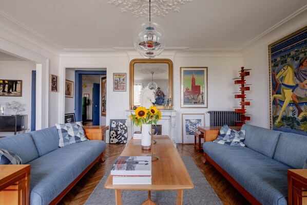 A living room with two sofas, a coffee table, and a chandelier.