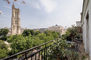 A balcony with a view of a historic tower and a large building with a dome.