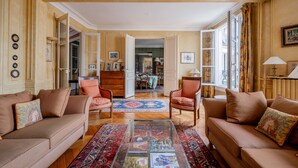 A spacious living room with a beige sofa set, a coffee table with magazines, and a patterned rug. - Mellow Grace, by Veeve (Paris)