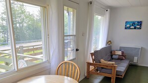 A room with a round wooden table and two chairs, a sofa, and a radiator. - Mazinaw Lakeside RV Park & Campground (Cloyne)