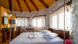 Ein rustikaler Holzraum mit einem Bett, einem Holztisch und einer Steinwand.