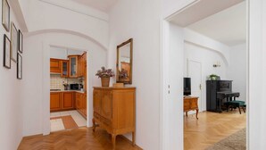 Ein geräumiger Wohnbereich mit Holzboden, einem Holzschrank, einem Spiegel und einem Kamin.