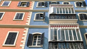 Un edificio de varios pisos con balcones, ventanas grandes y un estilo arquitectónico clásico.