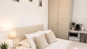 A bedroom with a bed, bedside table, lamp, and a wardrobe. - City Penthouse Suite w/ Terrace (Gibraltar)