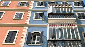Un edificio de varios pisos con balcones, ventanas grandes y un estilo arquitectónico clásico.