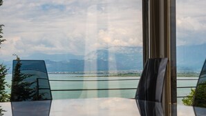 A view from a window overlooking a body of water with mountains in the distance.