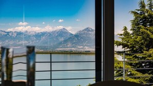 Una habitación con vistas a montañas y un lago.