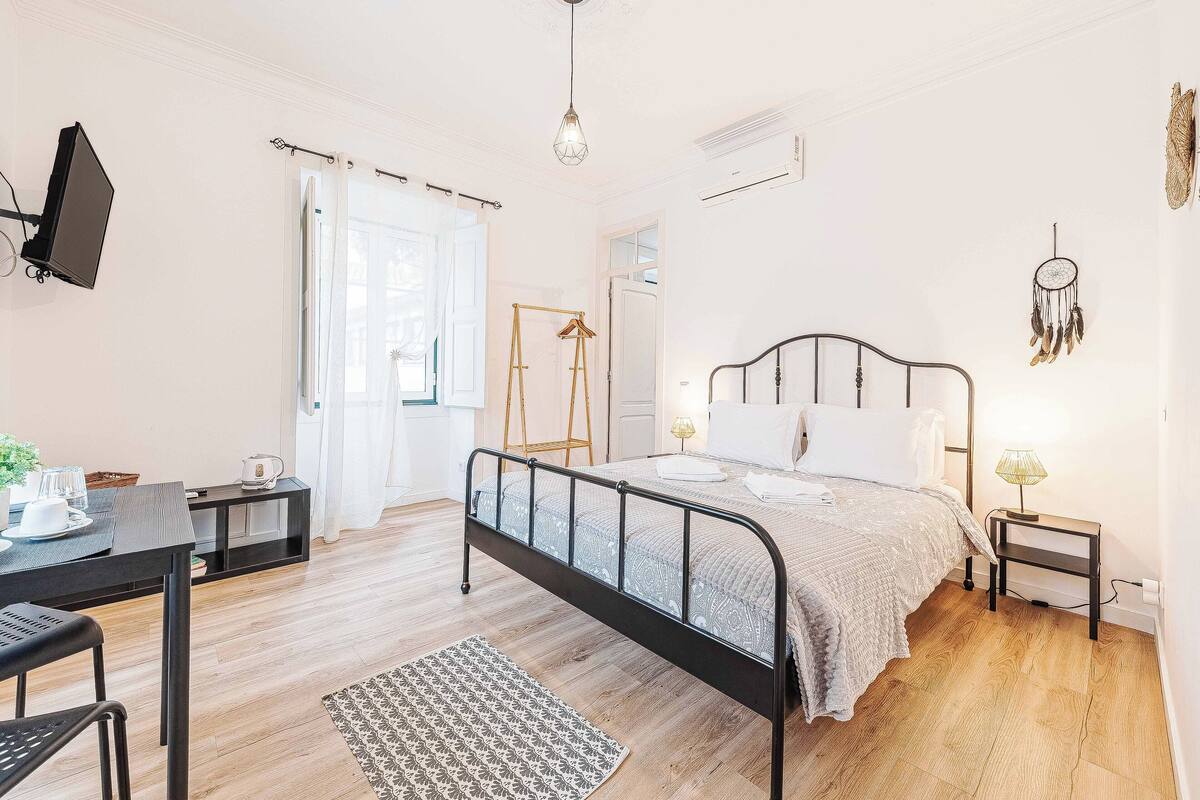 Ein Schlafzimmer mit einem Bett, Nachttischen, einem Schreibtisch und einem Stuhl.