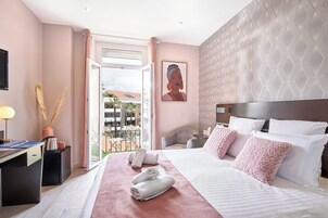 Habitación de hotel con una cama grande, un escritorio, una silla y vistas al exterior.