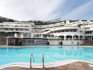A pool area with a sign for 'Long Play Chillout' and a boat dock.