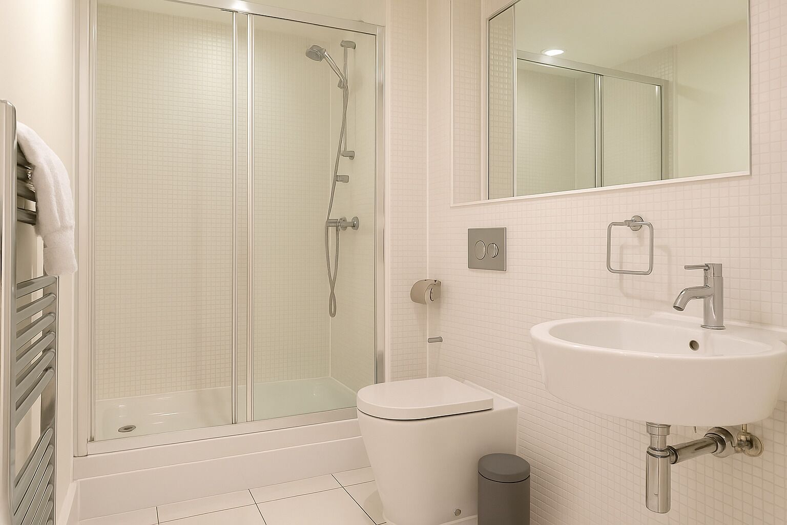 A modern bathroom with a glass-enclosed shower, a white sink, and a mirror above the sink.