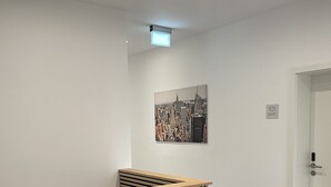 A reception area with a wooden slatted desk, a cityscape painting on the wall, and a door marked with the number 101. - Hotel am Bahnhof Ditzingen (Ditzingen)