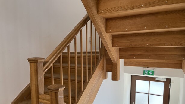 A wooden staircase with a handrail and a door with a frosted glass panel. - Hotel am Bahnhof Ditzingen (Ditzingen)