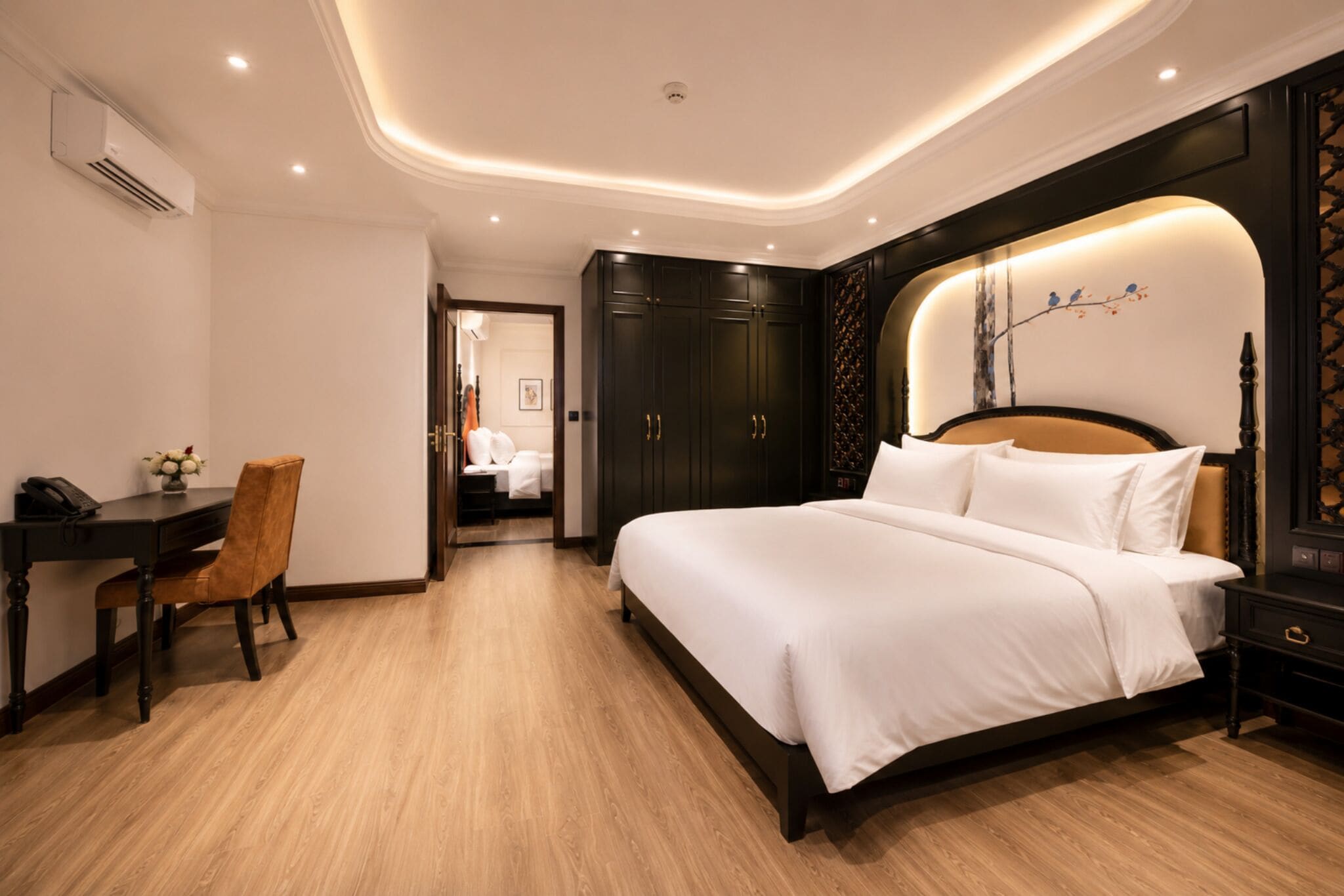Una habitación de hotel con cama, escritorio, silla y armario.