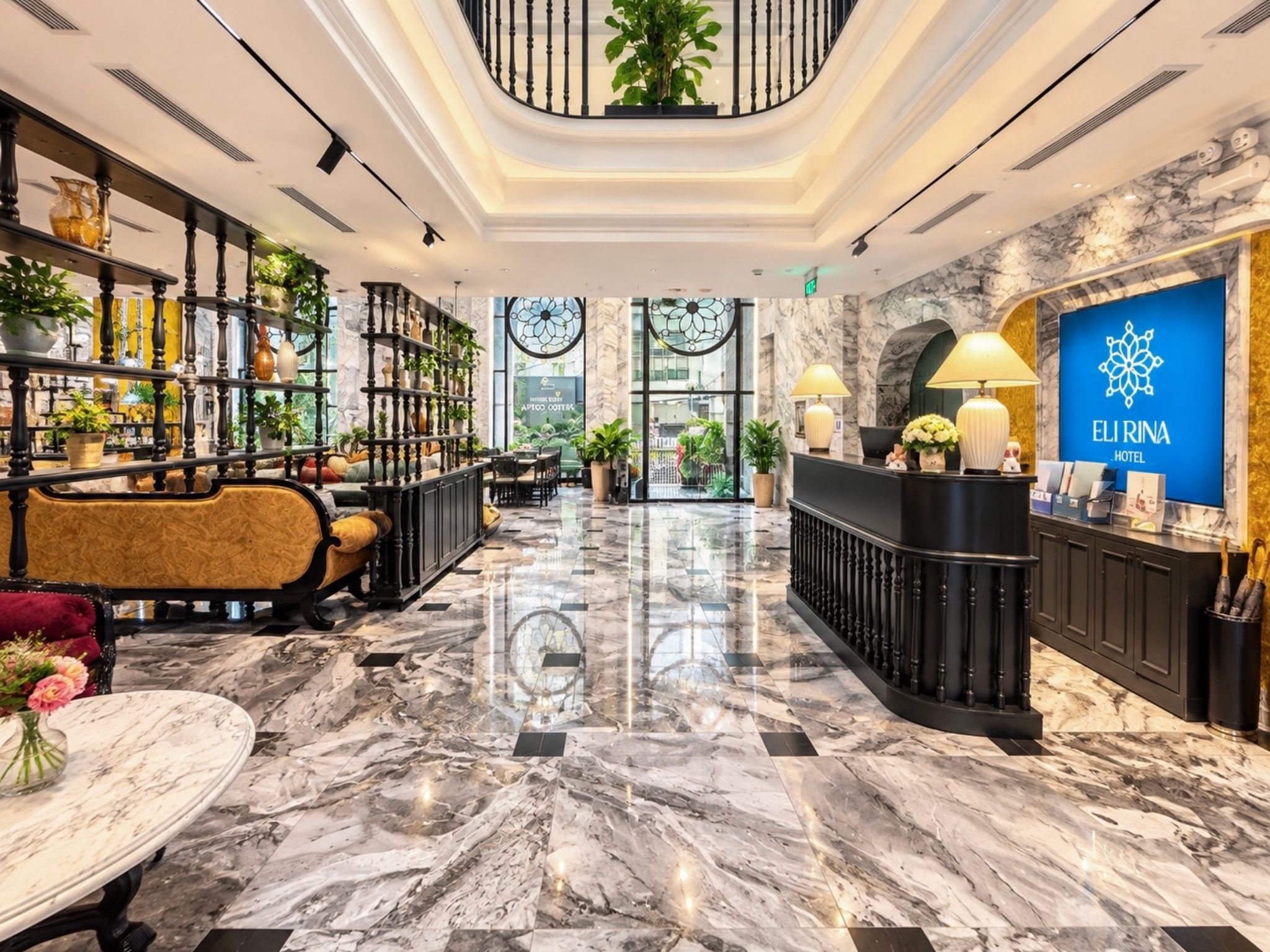 Eine Hotelhalle mit Marmorboden, einer Rezeption, einer Sitzecke und einer Treppe.