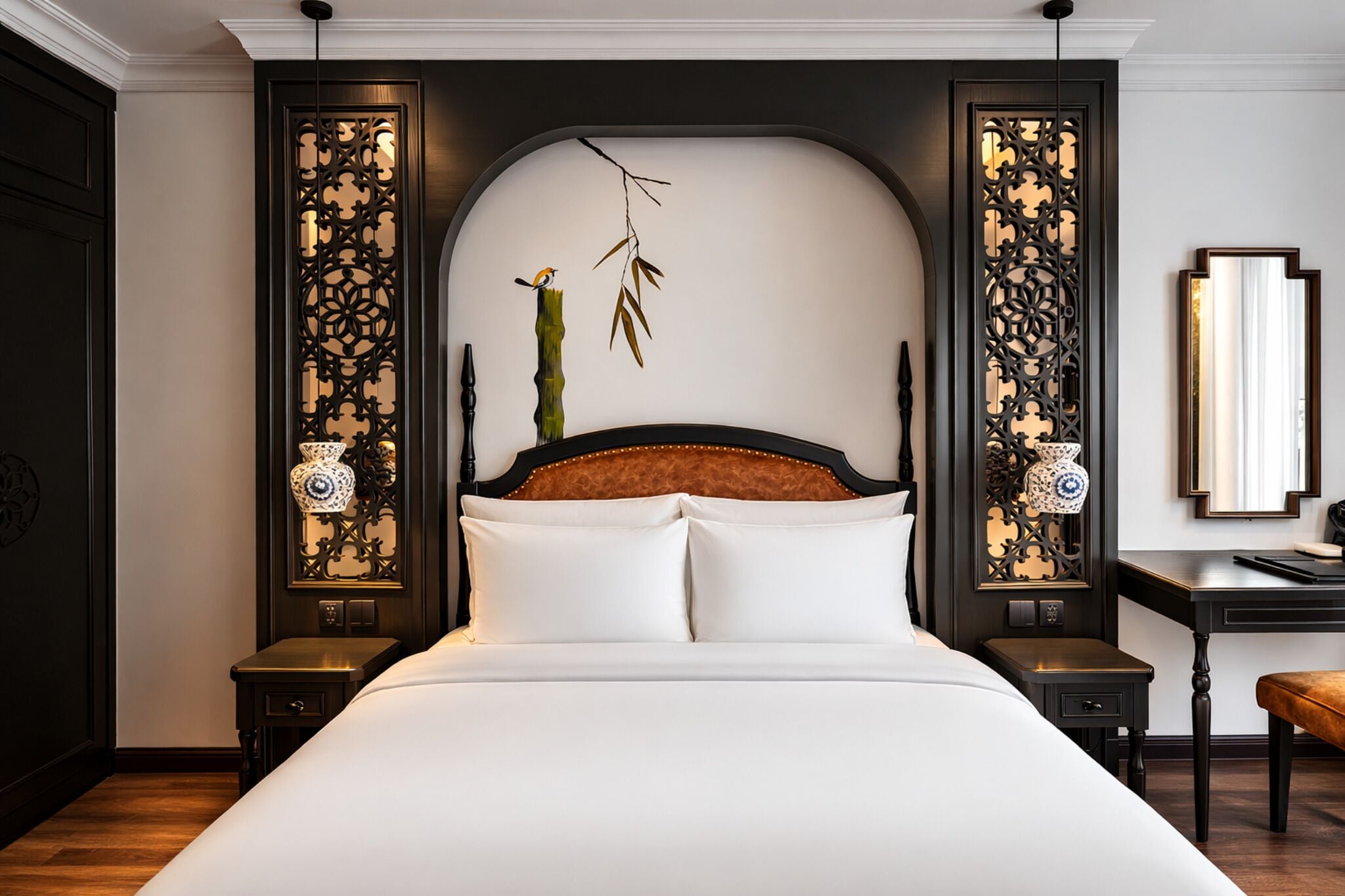 Een hotelkamer met een groot bed, een houten hoofdbord, decoratieve wandpanelen en een nachtkastje met een lamp.
