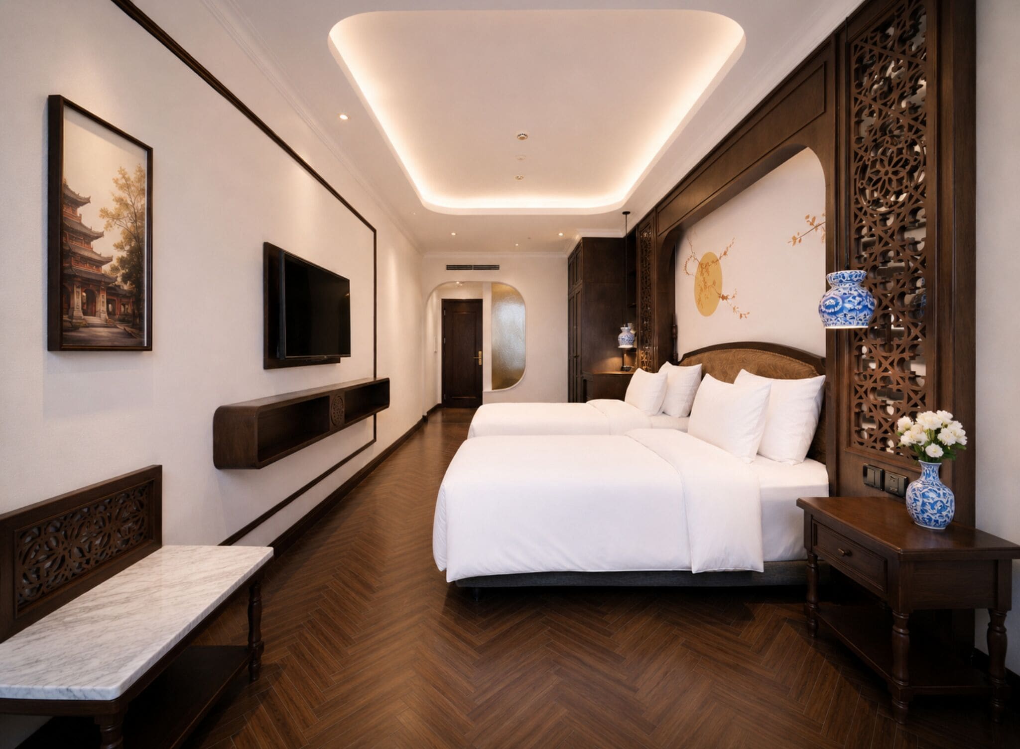 A hotel room with a large bed, a TV, a bench, and a decorative wall.