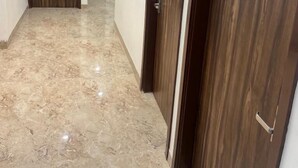 A hallway with wooden doors and a marble floor. - D 0101 Cafe and Lounge (Amritsar)