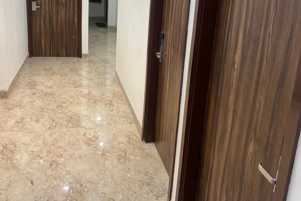 A hallway with wooden doors and a marble floor.