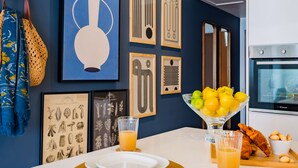 A modern kitchen with a white countertop, a bowl of lemons, a glass of orange juice, and a loaf of bread. - Cascais Modern & Quiet Retreat (Cascais)