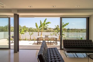 Un intérieur moderne avec une grande porte-fenêtre coulissante donnant sur un patio extérieur.