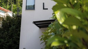 A modern building with the word "MOTEL" on its facade, surrounded by greenery.