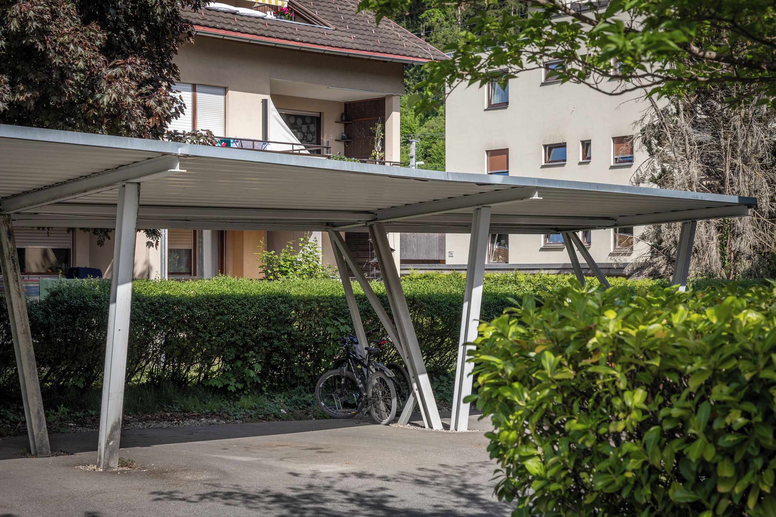 A covered outdoor area with a bicycle parked under a metal structure.
