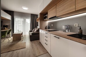 Una cocina moderna con armarios de madera, microondas integrado y hervidor.