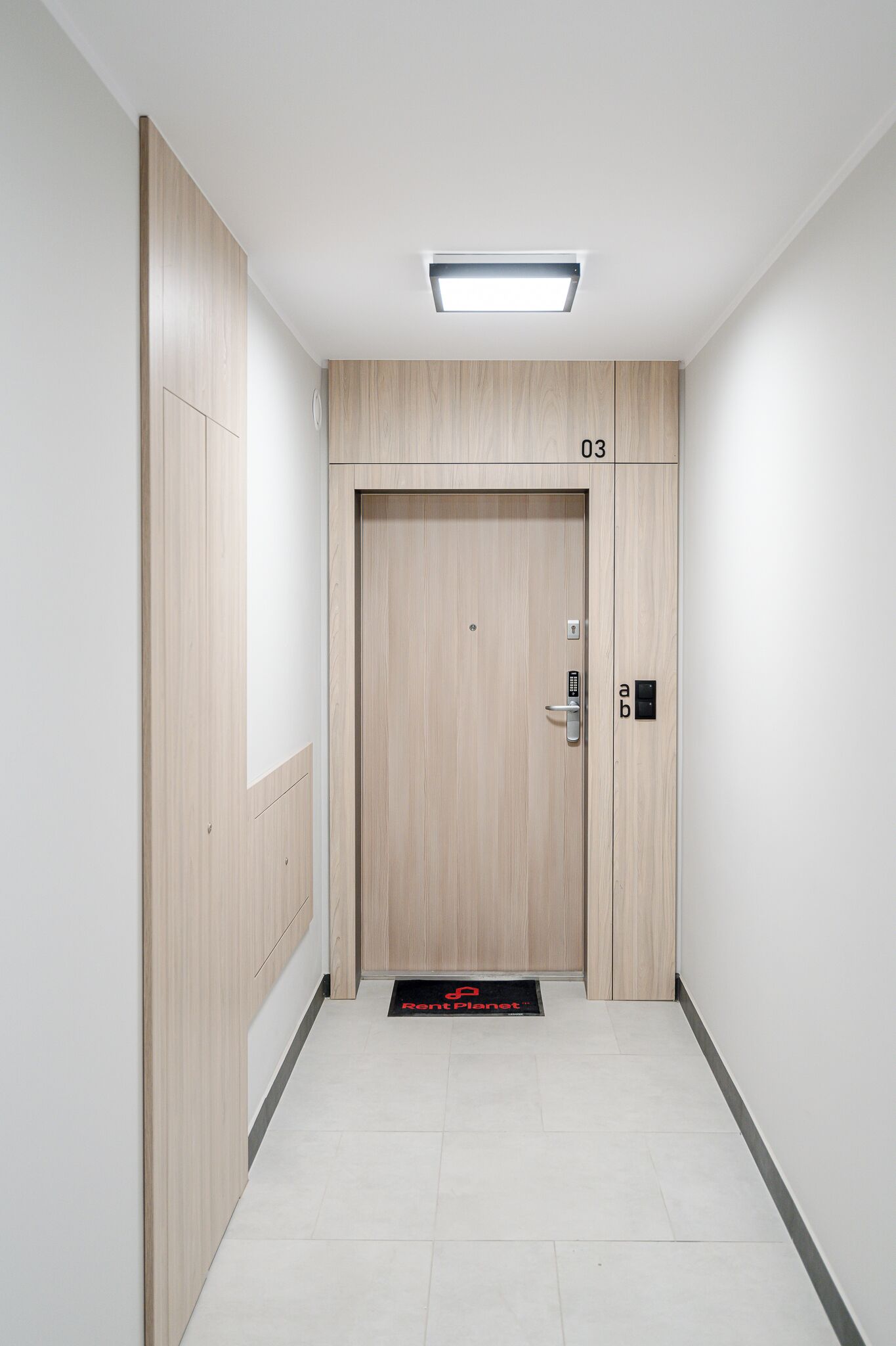 Un ascenseur moderne avec un revêtement en bois, un écran numérique et une porte portant le numéro 03.