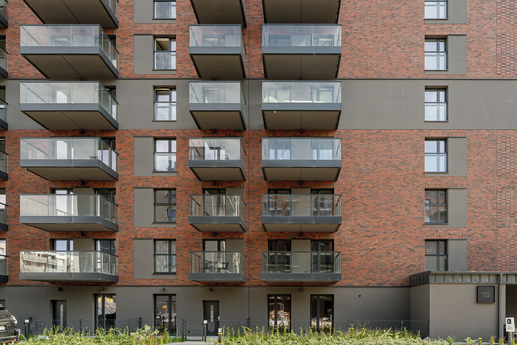 A multi-story building with balconies, brick facade, and multiple windows.