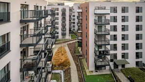 A modern apartment complex with multiple balconies, a central pathway, and a small garden area. - RentPlanet - Atal City Square (Wroclaw)
