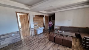 Amplia sala de estar con piso de madera, un sofá, una mesa de centro y un mueble de entretenimiento de madera empotrado.