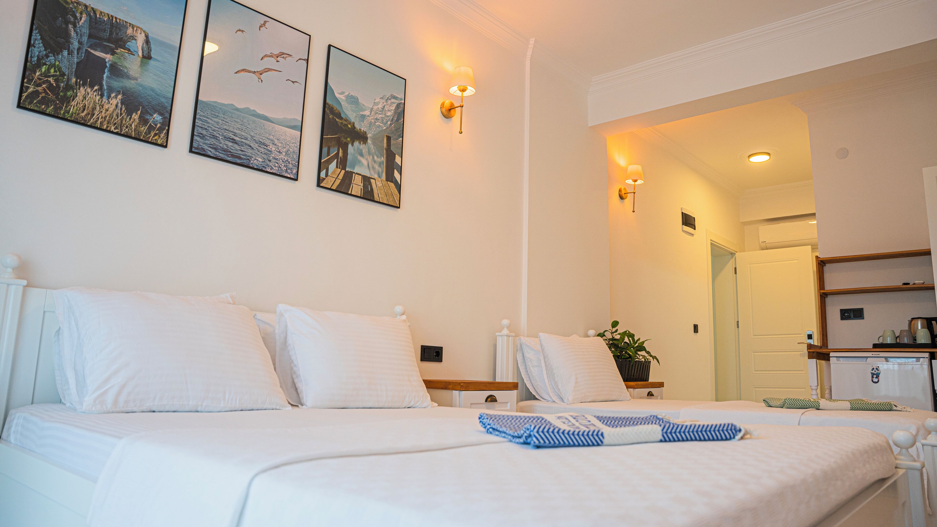 A hotel room with a large bed, a bedside table, a lamp, and a wall-mounted picture.
