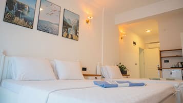 A hotel room with a large bed, a bedside table, a lamp, and a wall-mounted picture.
