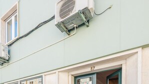 Un edificio con calle adoquinada, puertas verdes y el número 87.