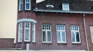 Un bâtiment en briques doté d’une tourelle et de nombreuses fenêtres.