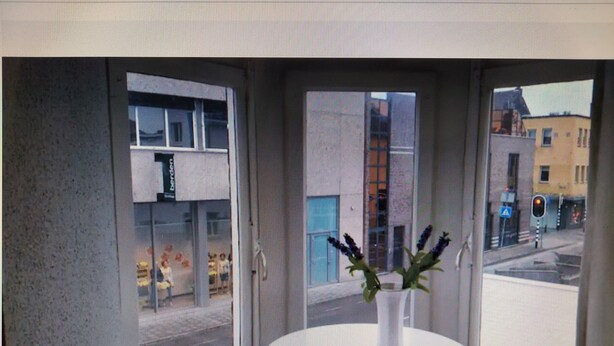 Une pièce avec une table ronde et un vase rempli de fleurs.