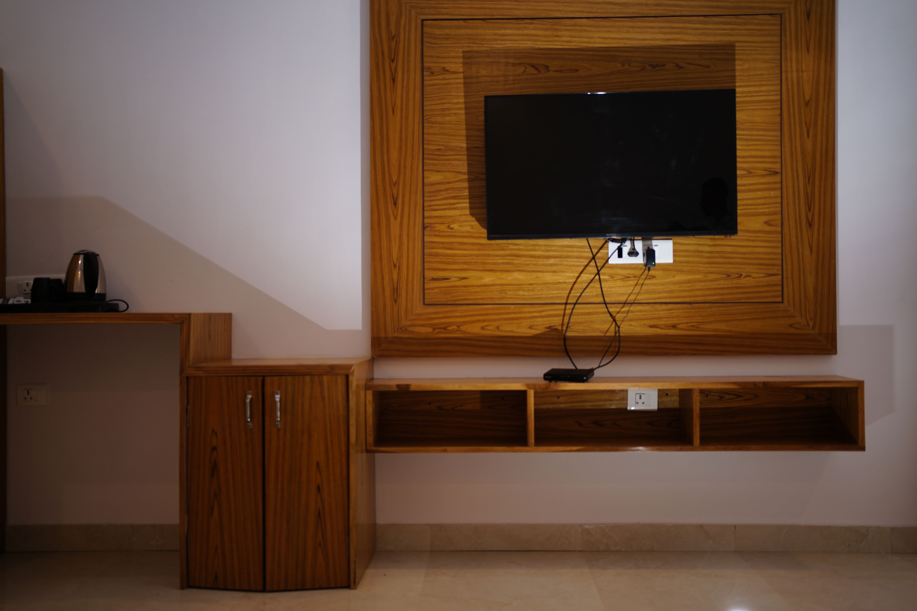 A wooden TV stand with a flat-screen TV mounted above it.