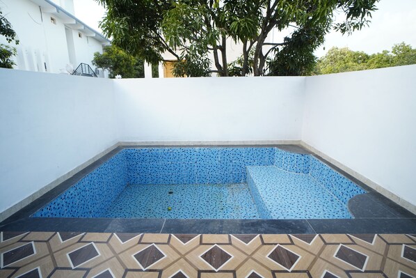 A swimming pool with blue tiles and a geometric tile pattern around it. - THE WHITE OAK CORBETT SPA & RESORT (Ramnagar)