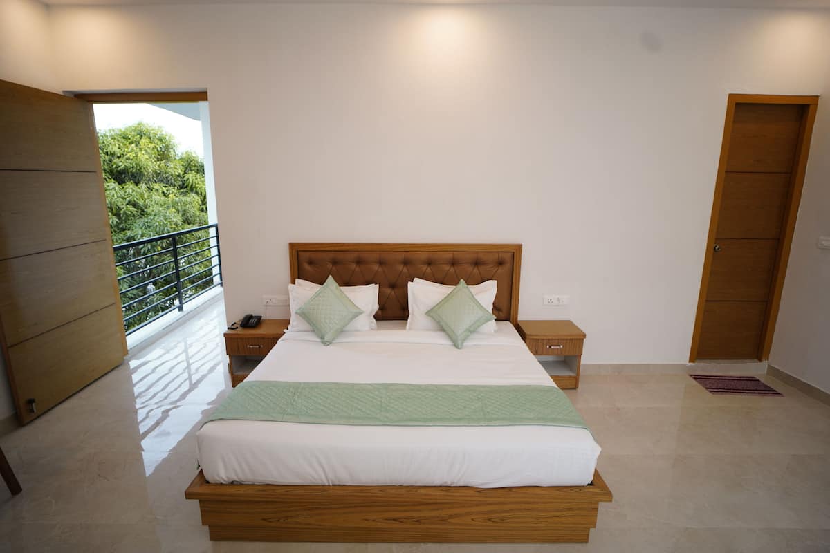 A bedroom with a wooden bed, two bedside tables, and a view of the outdoors.