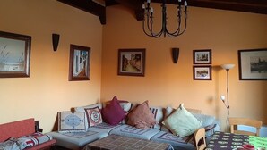 A cozy living room with a sofa, a table, and a chandelier. - Chalet en Grajera (Grajera)