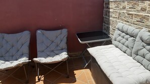 A patio area with two cushioned chairs, a small table, and a sofa. - Chalet en Grajera (Grajera)