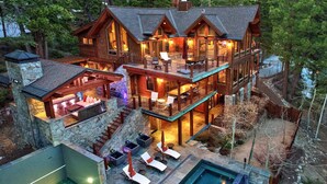 A multi-level log cabin with a pool, outdoor seating, and a stone chimney. - 450 Jill Court | 5BR/5.5BA Incline Village, Lake Views, Hot Tub (Incline Village)