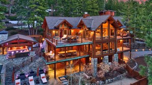 A multi-level wooden cabin with outdoor seating areas and a stone foundation. - 450 Jill Court | 5BR/5.5BA Incline Village, Lake Views, Hot Tub (Incline Village)