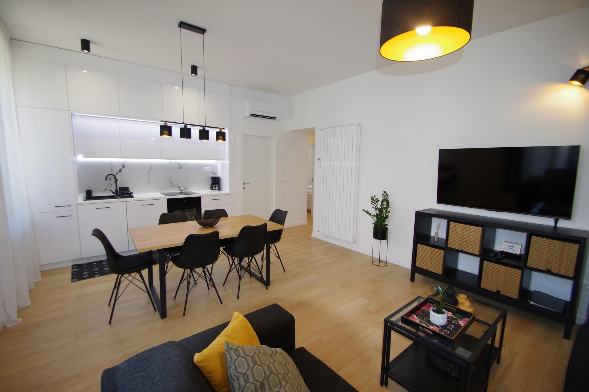 Eine moderne Wohnung mit Essbereich, Wohnzimmer und Fernseher.