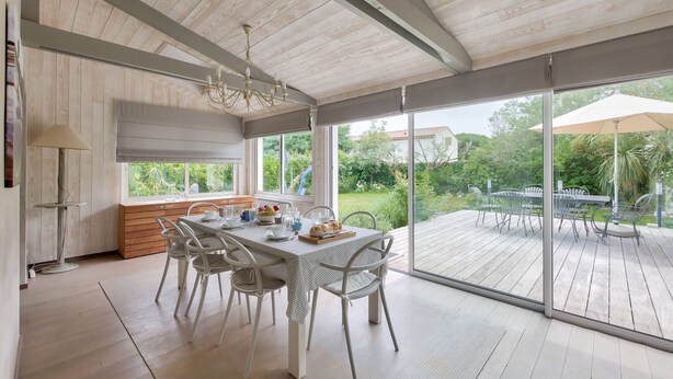 Un comedor con una mesa preparada para cuatro personas, un banco y vistas al exterior.