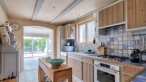 Una cocina con armarios de madera, estufa y salpicadero de azulejos.