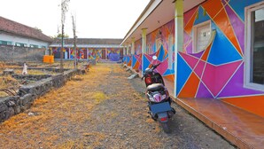 Un bâtiment aux couleurs vives, avec une moto garée devant.