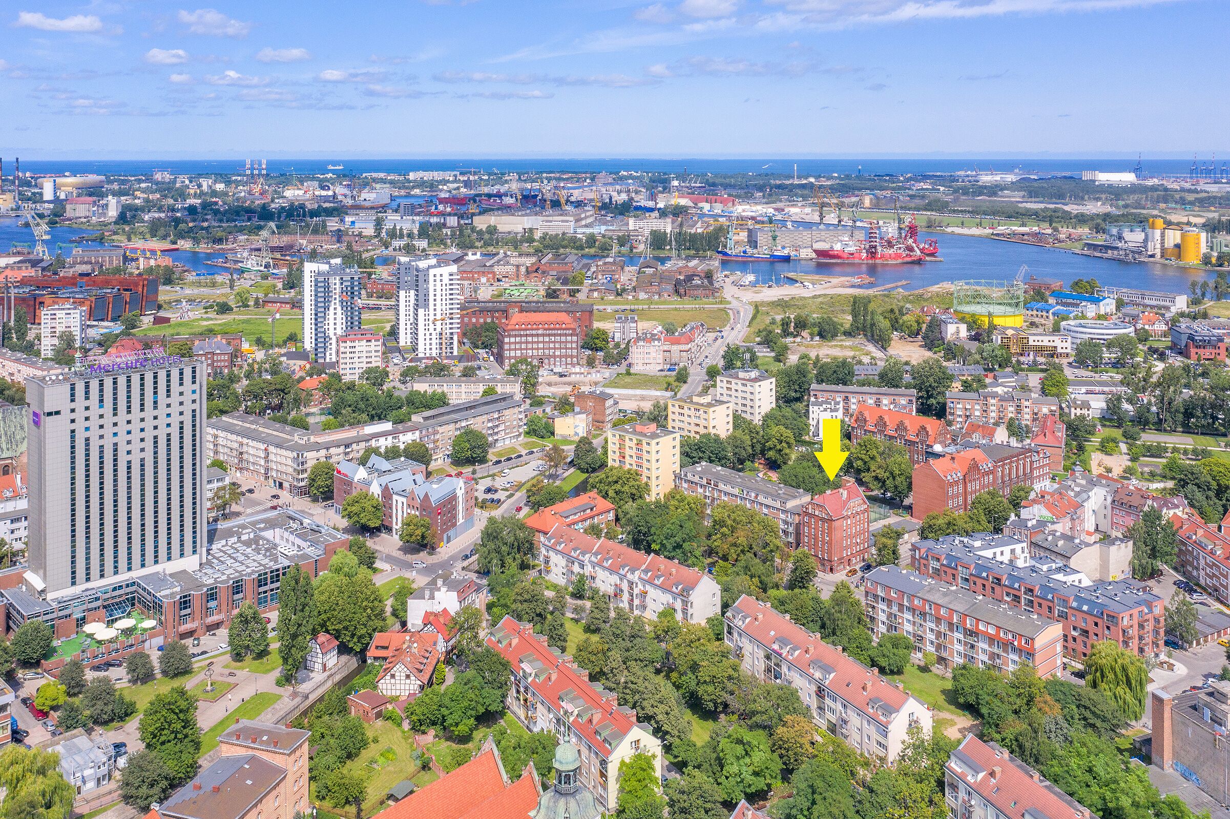 Ett flygbildsbild av en stad med en blandning av bostads- och kontorsbyggnader, en flod och ett stort industriområde.