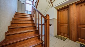 A wooden staircase with a handrail leading to a door. - Apartament Przytulny na Starym Mieście 2 sypialnie (Gdansk)